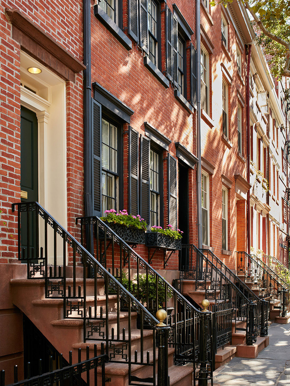 Brownstone buildings with cobblestone street in Little Bohemia.